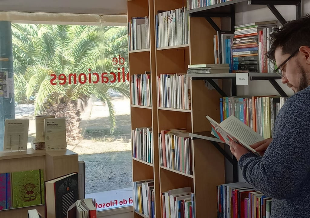 Hombre leyendo en el Interior de Librería Universitaria